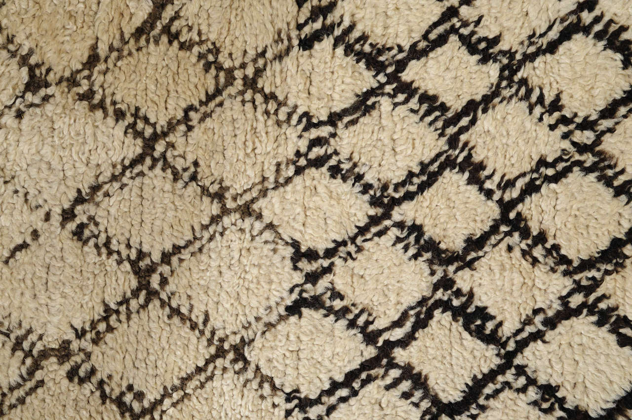 The carpets of the Beni Ouarain tribal confederacy differ from other Berber weavings in that they are woven exclusively with an ivory background and decorated with abstract geometric motifs of undyed natural wool. The high quality of the materials